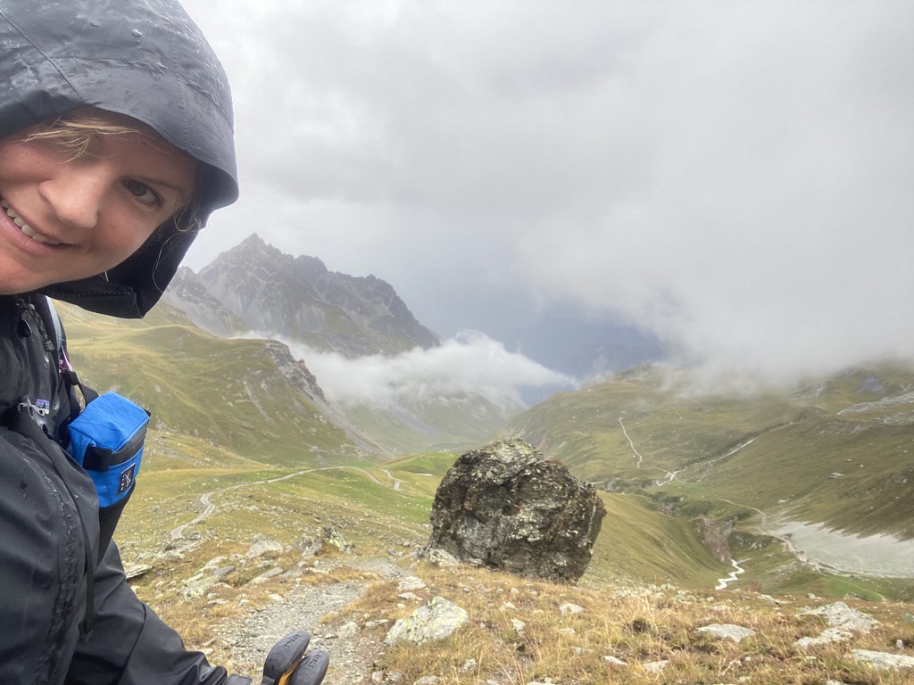 lydia high up in mountains with valley behind her